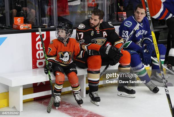 Ryker Kesler sits with his father Ryan Kesler of the Anaheim Ducks and Bo Horvat of the Vancouver Canucks near the bench area during the 2017 Coors...