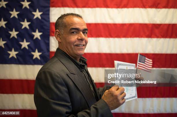 Carlos Jose Leonardo, originally from the Dominican Republic, stands for a picture holding his Certificate of Naturalization during a ceremony for...