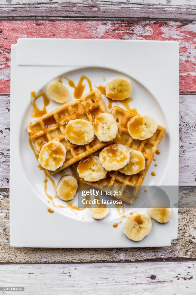 Waffels with banana slices and caramel syrup