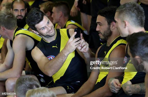 Trent Cotchin of the Tigers takes a photo of his team mates on his phone during the Richmond Tigers AFL Team Photo Day on February 17, 2017 at Punt...