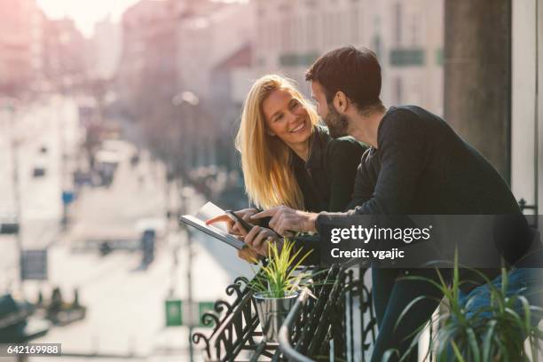 paar auf hotelbalkon - hotel stadt stock-fotos und bilder