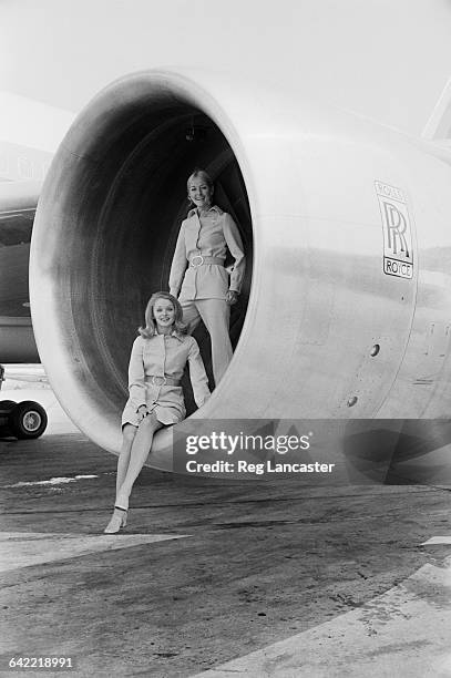 Cabin crew Marilyn Spillane and Rebecca Armstrong pose in the Rolls-Royce engine of a Lockheed L-1011 TriStar airliner at the Paris Air Show, France,...