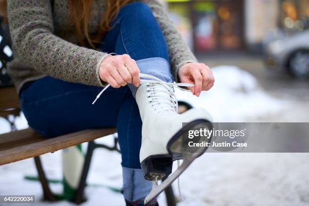 woman putting on ice skates (close-up) - ice rink stock-fotos und bilder