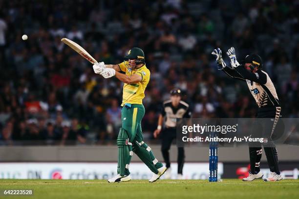 De Villiers of South Africa bats as Luke Ronchi of New Zealand looks on during the first International Twenty20 match between New Zealand and South...