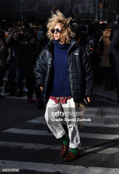 Guest is seen wearing a black puff jacket, white pants and blue sweater outside the Marc Jacobs show during New York Fashion Week: Women's...