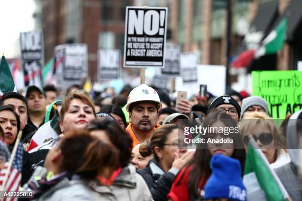 Thousands of demonstrators hold banners during a rally against US President Donald Trump's order and his recent policies regarding cracking down on...