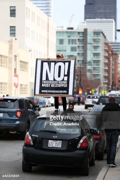 Protestor holding a placard is seen on a car during a rally against US President Donald Trump's order and his recent policies regarding cracking down...