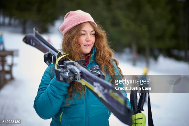 woman with ski looking down the piste - wintersport stock-fotos und bilder