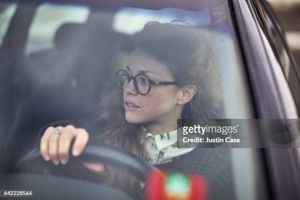 woman wearing glasses steering her car - learning to drive ストックフォトと画像