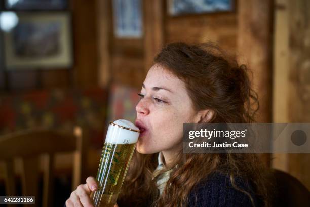 woman drinking a fresh beer in a bar - beer stock-fotos und bilder