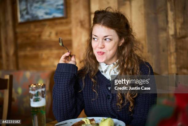 happy woman eating out in a restaurant - speisen und getränke stock-fotos und bilder
