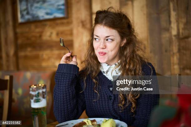 happy woman eating out in a restaurant - fork photos et images de collection