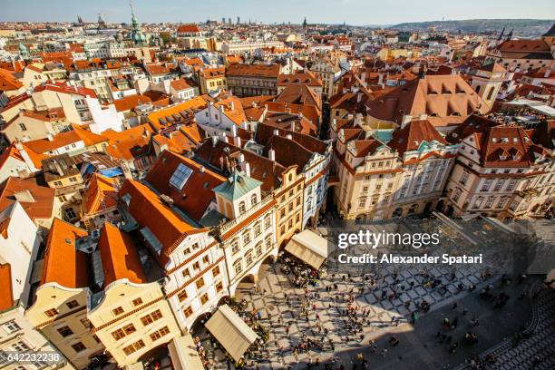 orange roofs of prague old town and town square with tourists seen from above, czech republic - stare mesto stock-fotos und bilder