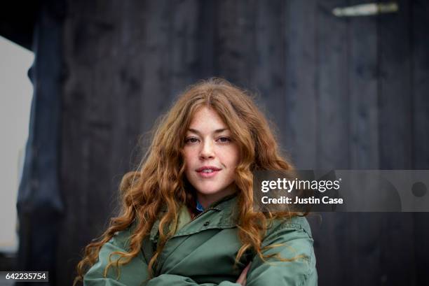 portrait off a woman in front of wooden barn - groen jak stockfoto's en -beelden