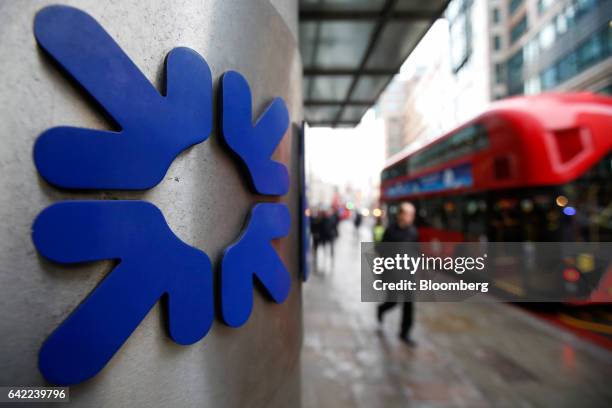 Commuters and traffic pass logos outside Royal Bank of Scotland Group Plc offices in London, U.K., on Wednesday, Feb. 15, 2017. RBS is preparing to...