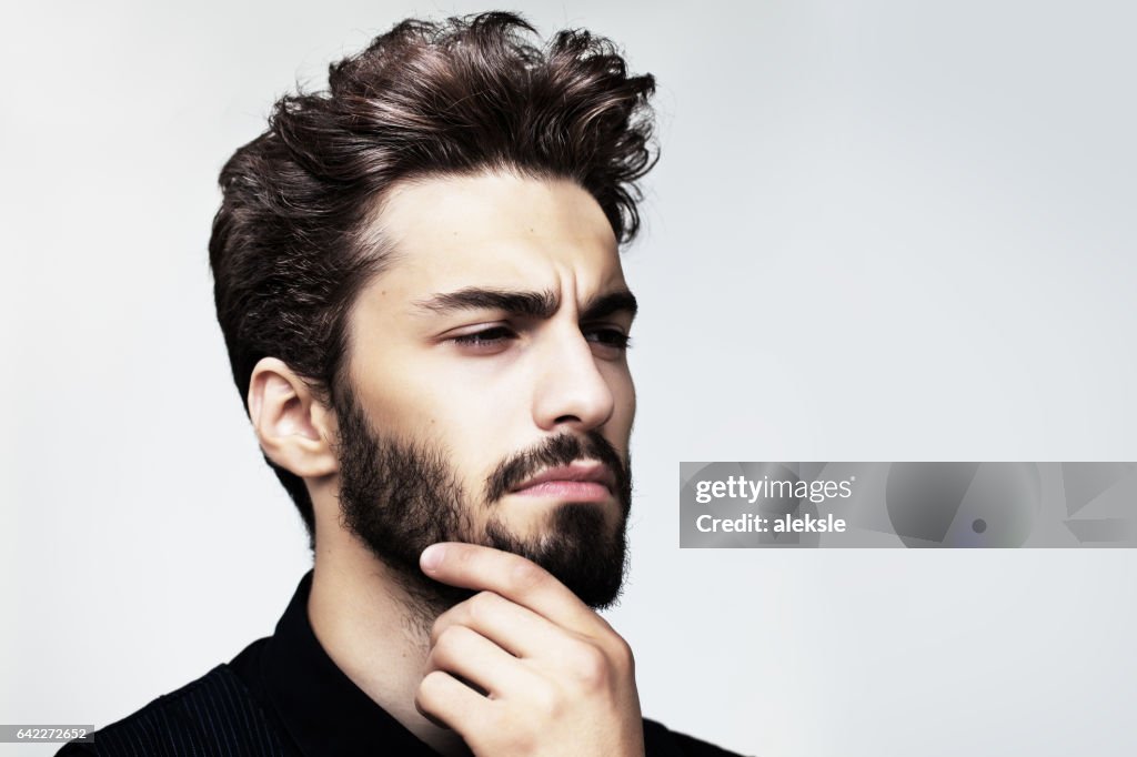 Homem elegante barbudo posando ao ar livre