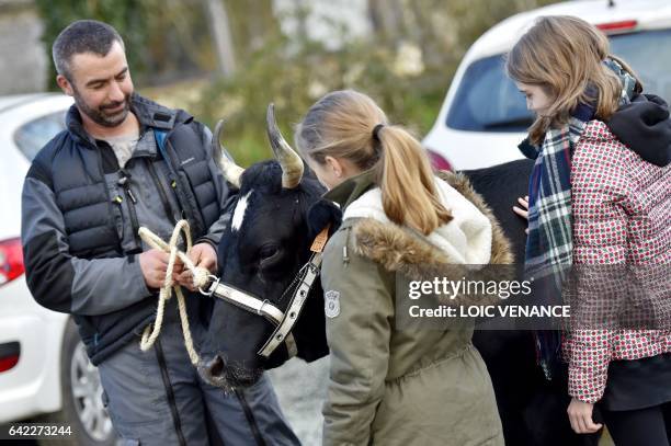 French farmer Cedric Briand talks to visitors about his French Pie Noir dairy cow, Fine, which is the brand ambassador of the 54th edition of the...