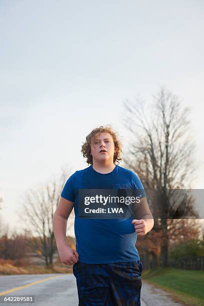 teen boy jogging - chubby teen stockfoto's en -beelden