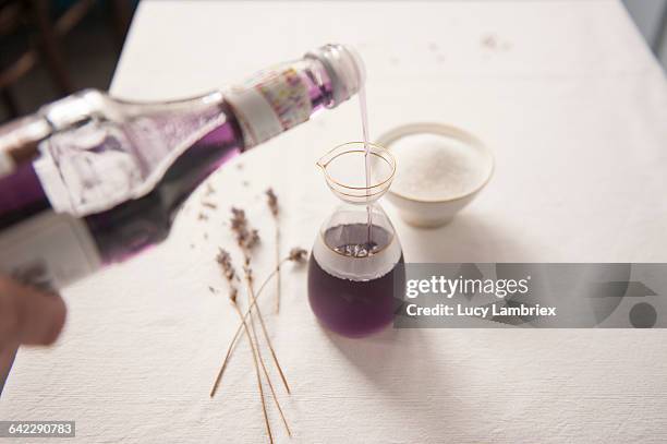 pouring lavendar syrup into a glass jug - syrup stock pictures, royalty-free photos & images