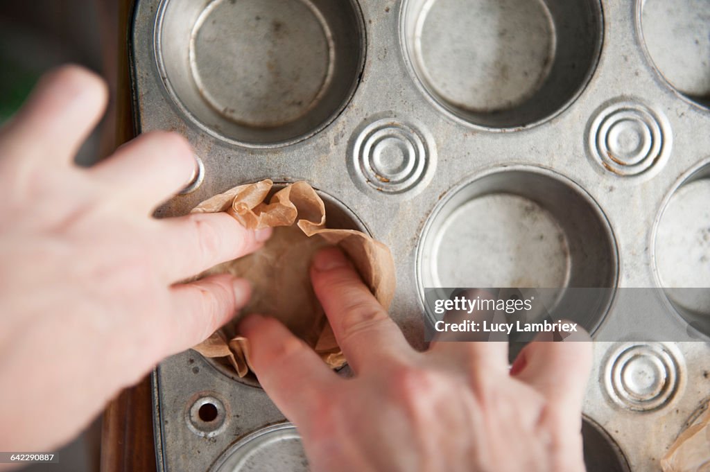 Adding parchment paper linings to a baking tin