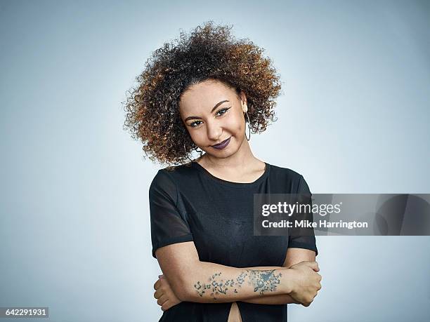 young black female smiling to camera - tattoo arm stockfoto's en -beelden