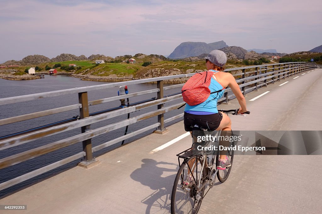 Woman riding bicycle in Solund Islands, Norway