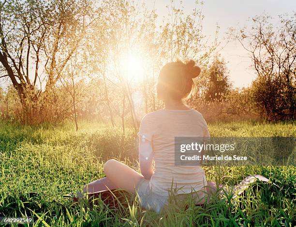 young woman enjoying sunset - woman yoga trees ストックフォトと画像