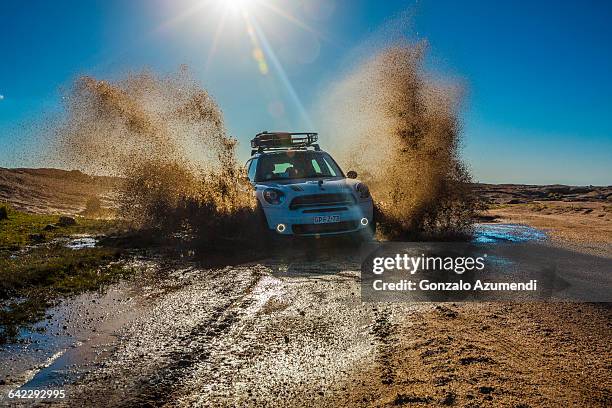 driving a mini over the mud off road - 4x4 desert stock-fotos und bilder