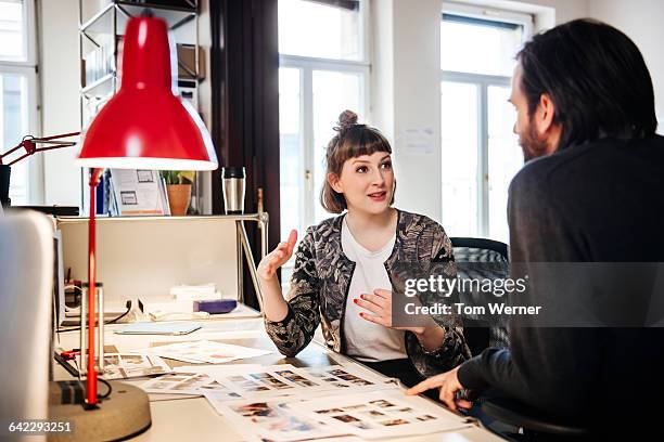 young graphic designer talking with colleague - diseñador gráfico fotografías e imágenes de stock