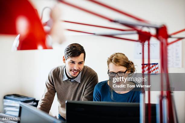 two young start up people in their office - side by side stock pictures, royalty-free photos & images