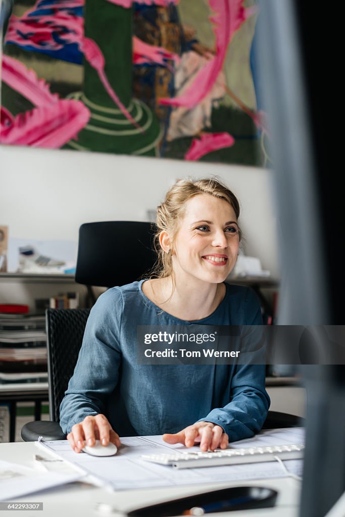 Young casual businesswoman working at computer