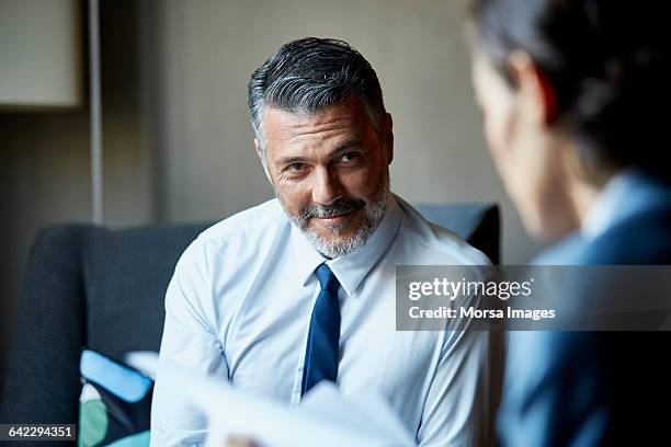 businessman looking at colleague in hotel room - levantar las cejas fotografías e imágenes de stock