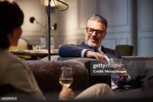 businessman with a drink sitting in hotel - luxushotel stock-fotos und bilder