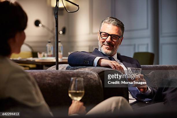 businessman with a drink sitting in hotel - millionnaire stock pictures, royalty-free photos & images