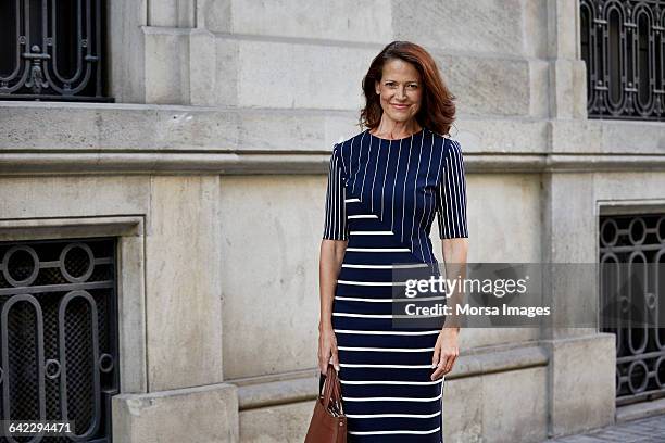 portrait of businesswoman against building - striped dress stock pictures, royalty-free photos & images