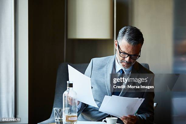 businessman reading documents in hotel room - ties foto e immagini stock