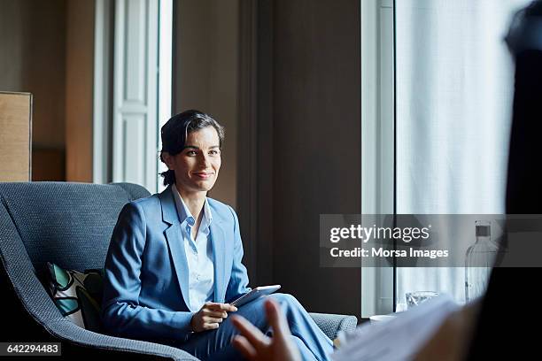 businesswoman with digital tablet in hotel meeting - businesswoman hotel stock pictures, royalty-free photos & images