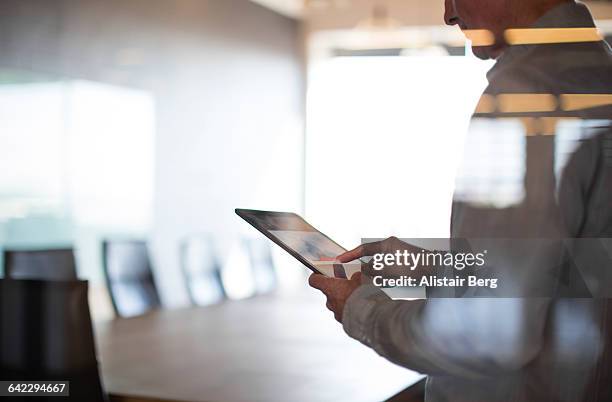 businessman using tablet in conference room - business handy stock pictures, royalty-free photos & images