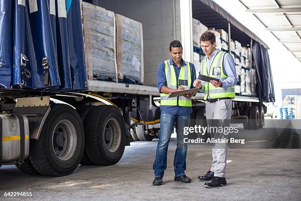 workers loading a lorry at a large warehouse - africa security stock-fotos und bilder