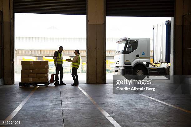 workers inside a food distribution warehouse - freight truck loading stockfoto's en -beelden