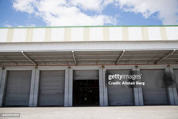 row of shutter doors at warehouse - industrial door stock pictures, royalty-free photos & images