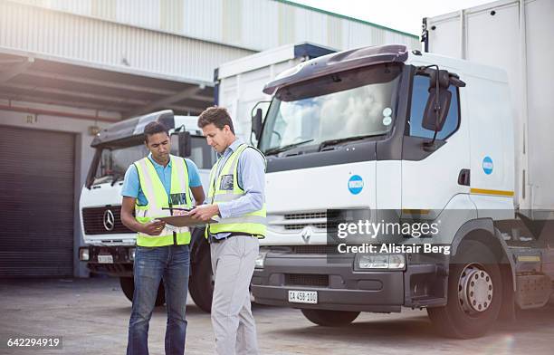 workers loading a lorry at a large warehouse - fahrzeuge stock-fotos und bilder