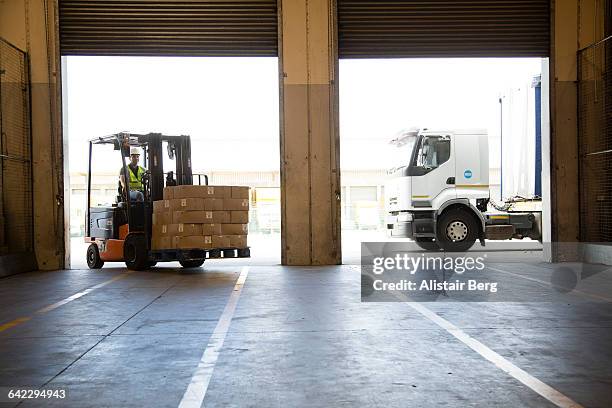 forklift truck unloading a lorry - entladen stock-fotos und bilder