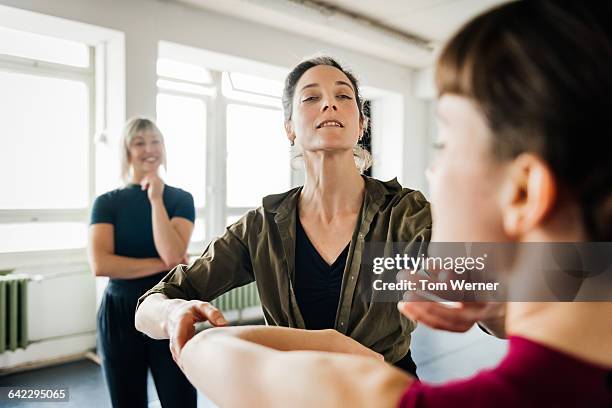 female teacher correcting dancer - dance instructor stock-fotos und bilder