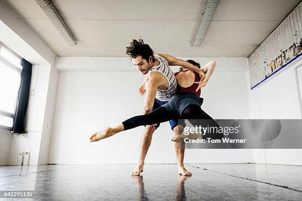ballet couple perfomring in dance studio - performance stock-fotos und bilder
