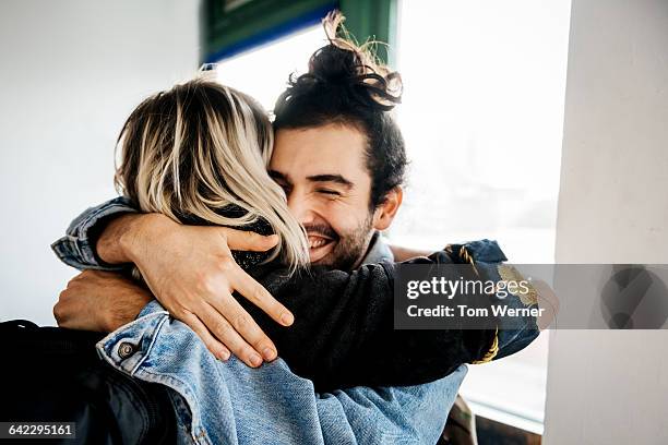 friends welcoming each other and hugging - homme rencontre femme photos et images de collection