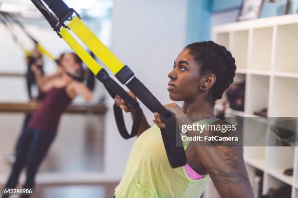 group of women doing barre + trx workout - suspension training stock pictures, royalty-free photos & images