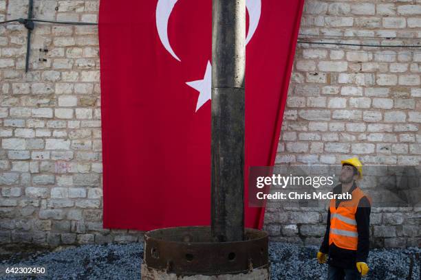 Construction worker watches on as work begins at the site of the new controversial Taksim Mosque after a ground breaking ceremony on February 17,...