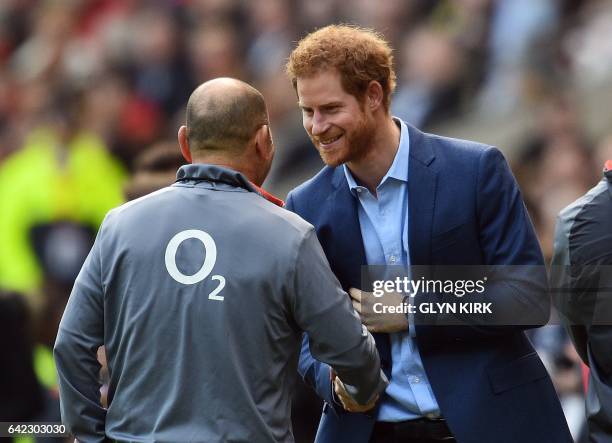 Britain's Prince Harry shakes hands with England's Australian head coach Eddie Jones during a team training session at Twickenham Stadium in...