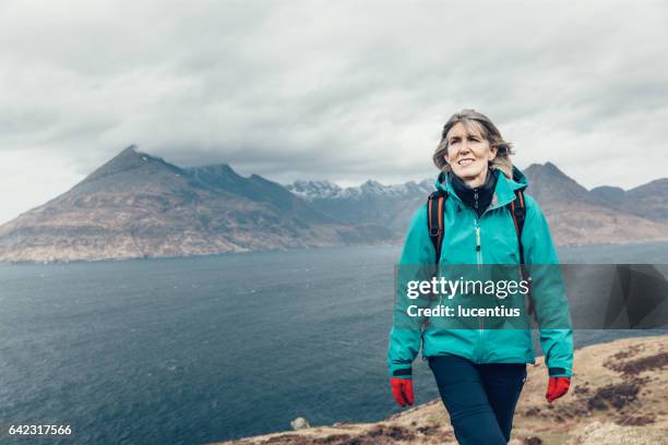 weibliche wanderer 50-59years, zu fuß auf küstenweg in skye, schottland - cuillins stock-fotos und bilder